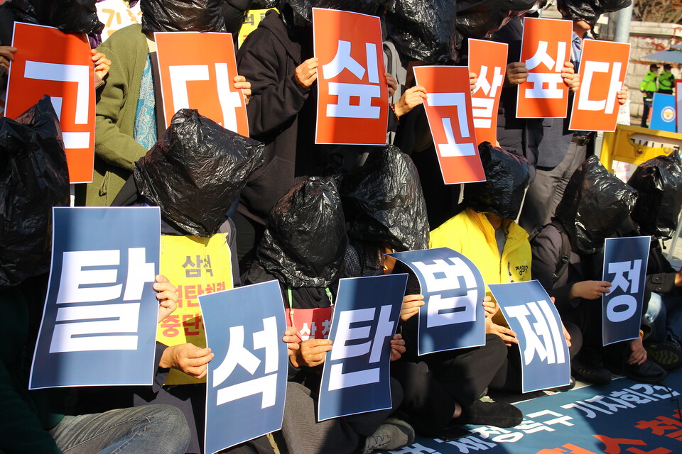 참가자들이 머리에는 검은 비닐을 쓰고 손에는 '살고 싶다'라고 적힌 피켓을 들고 있다 (사진 이수연 기자)/뉴스펭귄