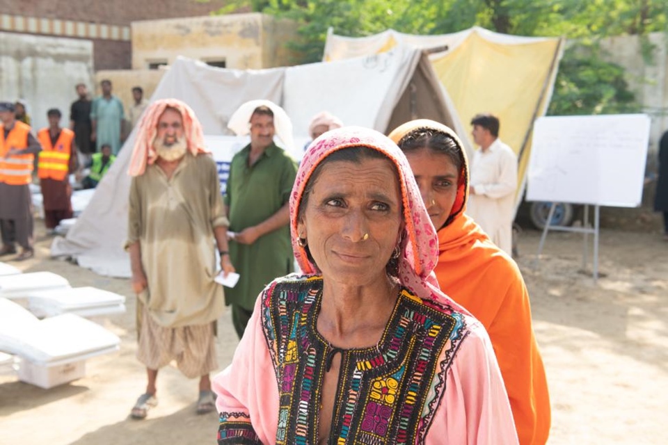 2022년 파키스탄 대홍수로 집을 잃은 여성이 구호 물자를 받기 위해 기다리고 있다. (사진 유엔국제이주기구)/뉴스펭귄