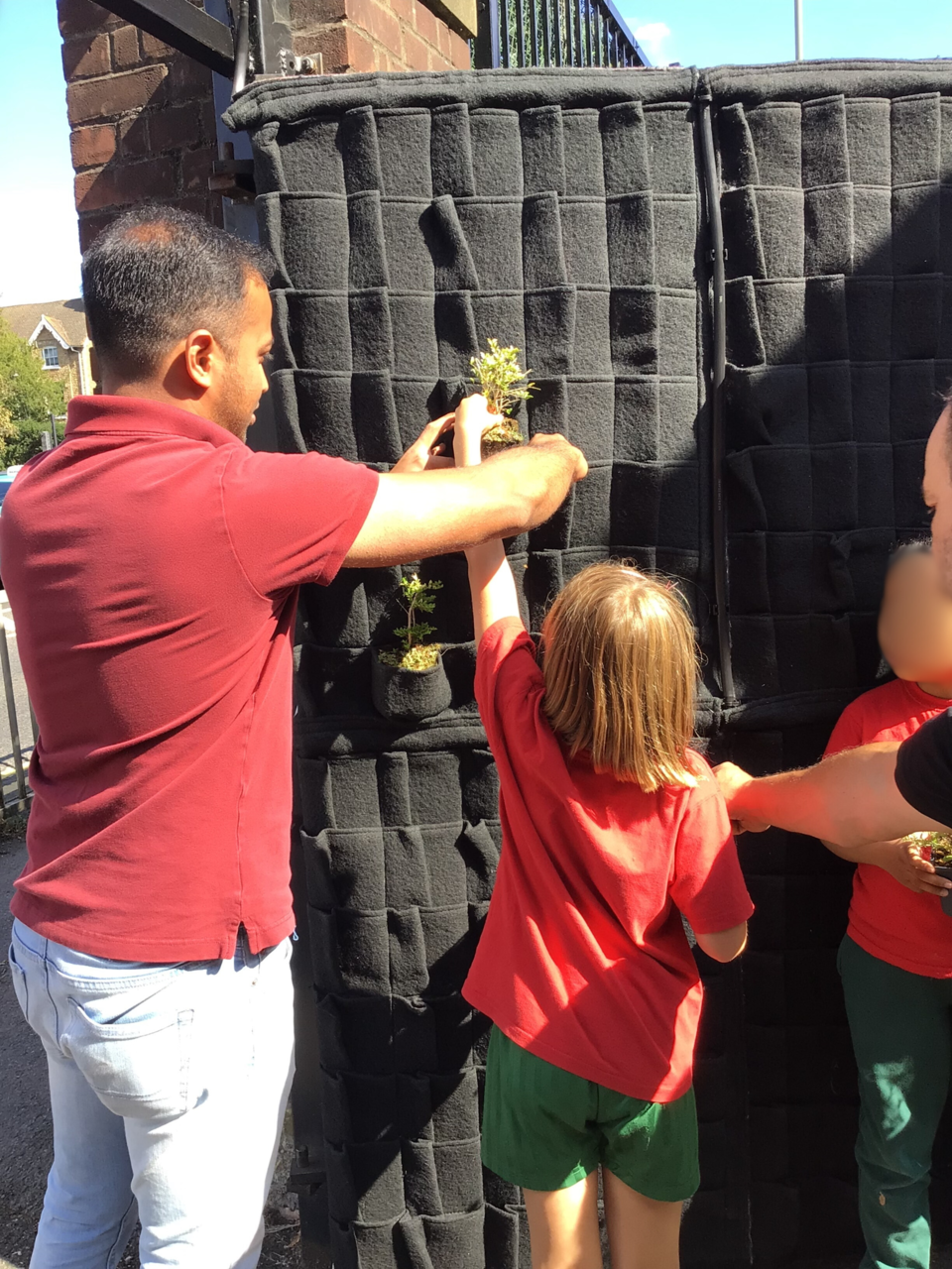 샌드필드초등학교 학생이 식물로 문을 채우고 있다. (사진 서리대학교)/ 뉴스펭귄