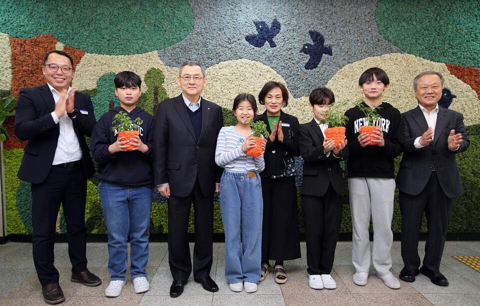 한화 그룹 관계자 등이 대전 진잠초 학생들과 함께 반려식물을 들고 기념촬영 하는 모습. (사진 한화)