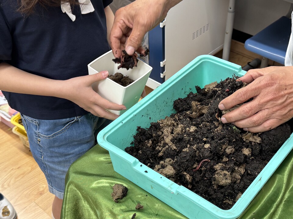 아이들 손에 쥐어지는 지렁이와 지렁이 집. 최훈근 박사가 직접 아이들에게 나눠주는 모습. (사진 우다영 기자)/뉴스펭귄