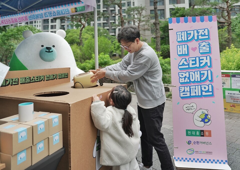 서울 강동구 고라시움아파트에 설치된 현대홈쇼핑의 '전자폐기물 자원순환 캠페인' 체험 부스를 아파트 주민이 이용하고 있는 모습. (사진 현대백화점그룹)/뉴스펭귄